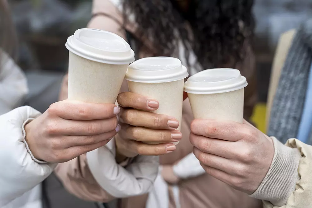 people holding warm coffee cups
