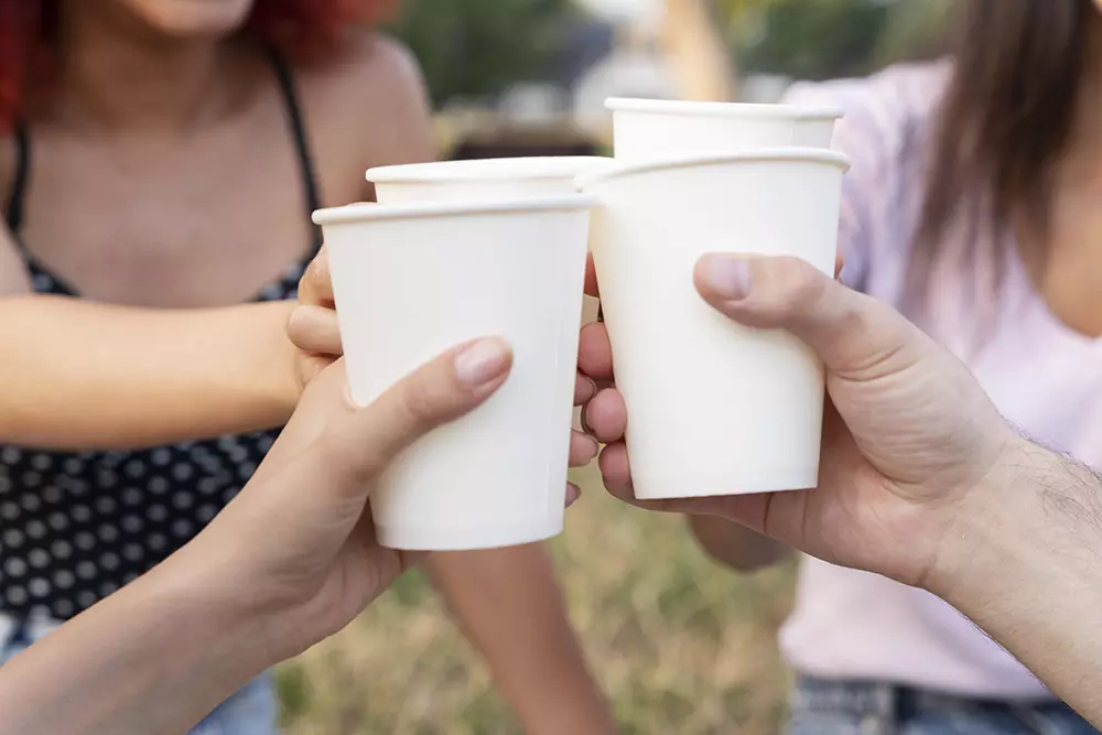 people holding plain paper cups