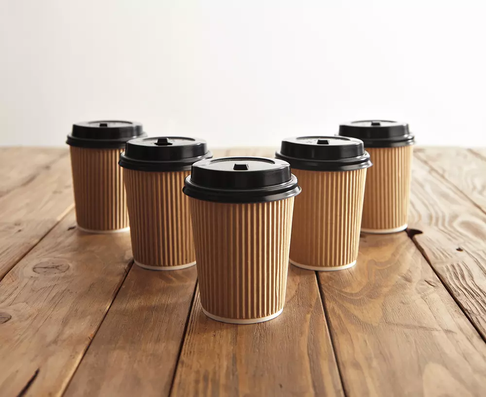 row of ribbed coffee cups with lids